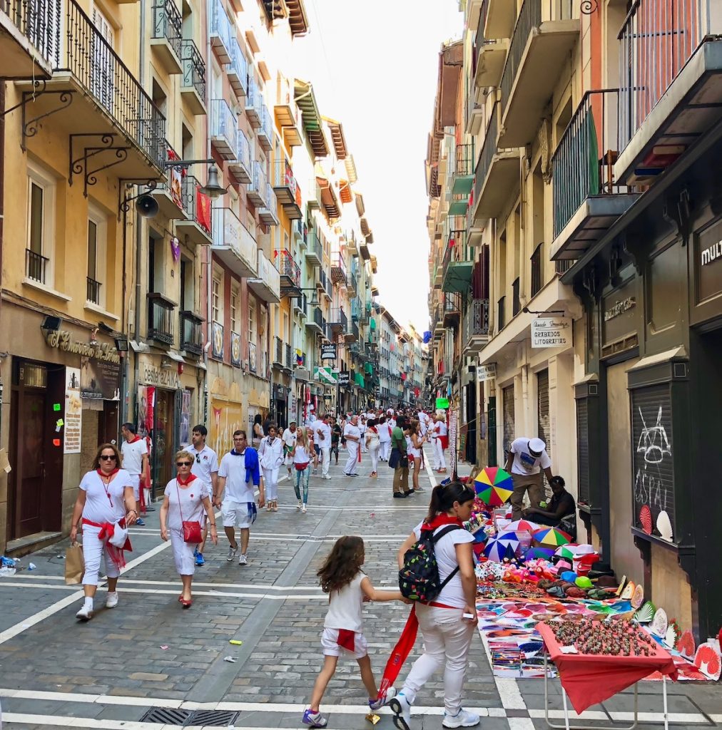 Spectators and participants wearing the customary red and white uniforms get ready for the run. 
